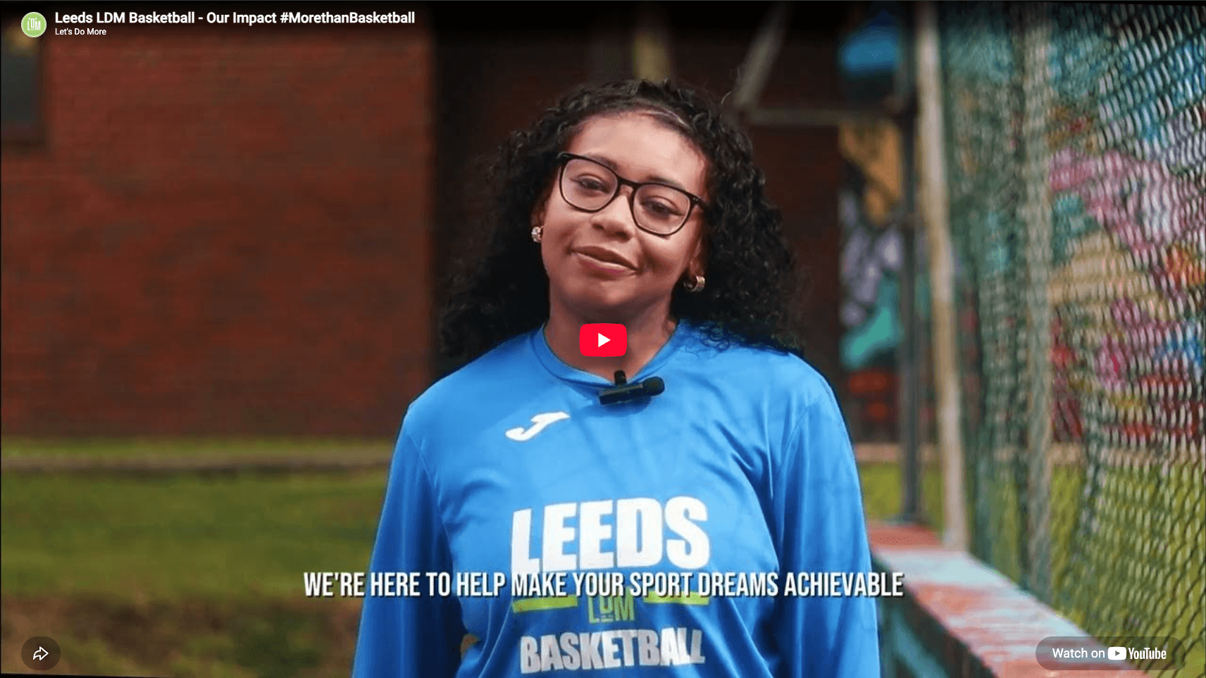 An LDM participant wearing a Leeds basketball shirt beside an outdoor court